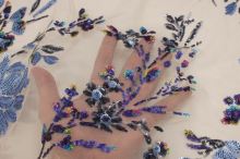 Vyšívaný tyl tělový, světle modrý flitrový květ, š.130/145